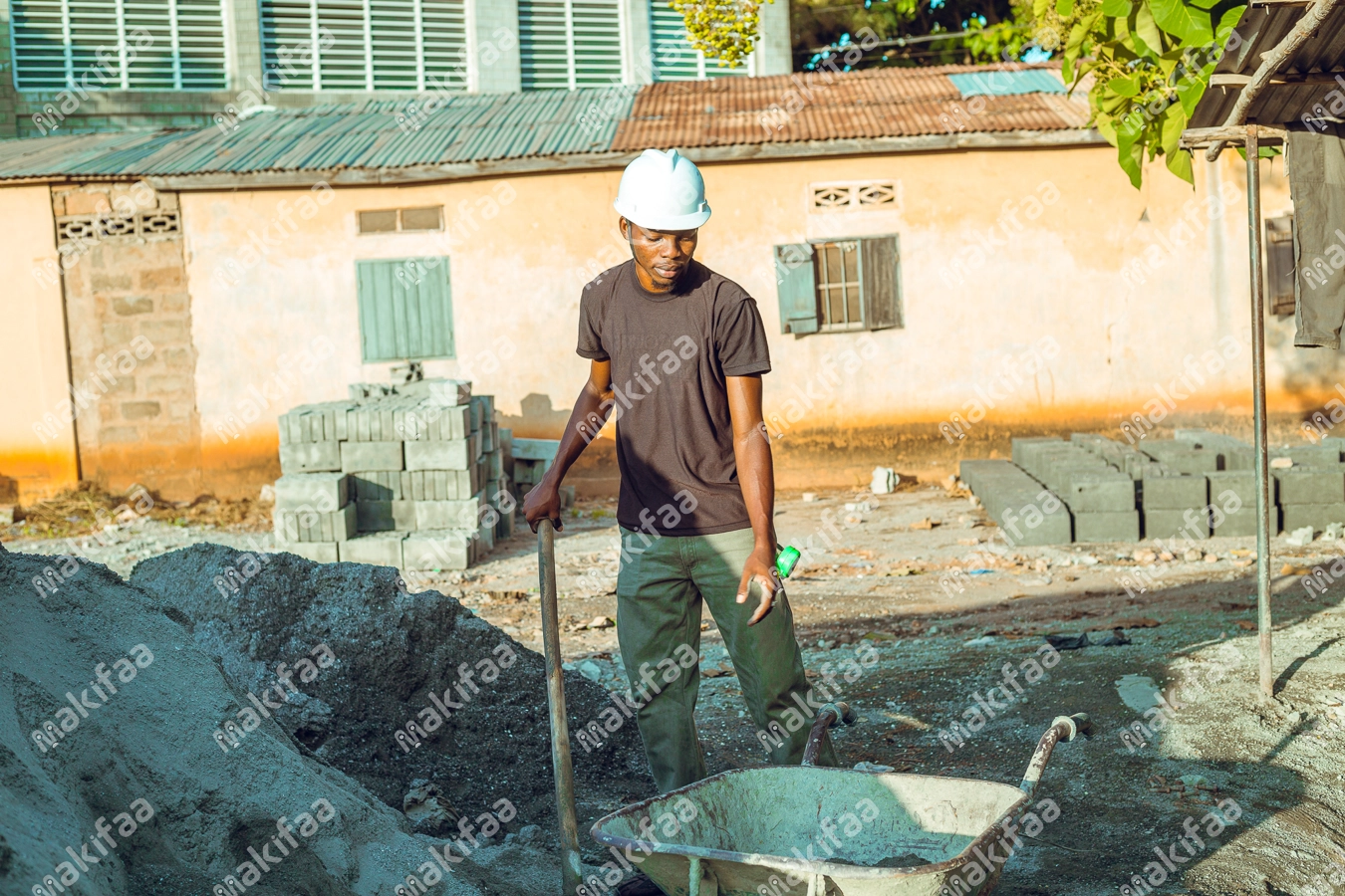 chef maçon sur un chantier tenant une pèle