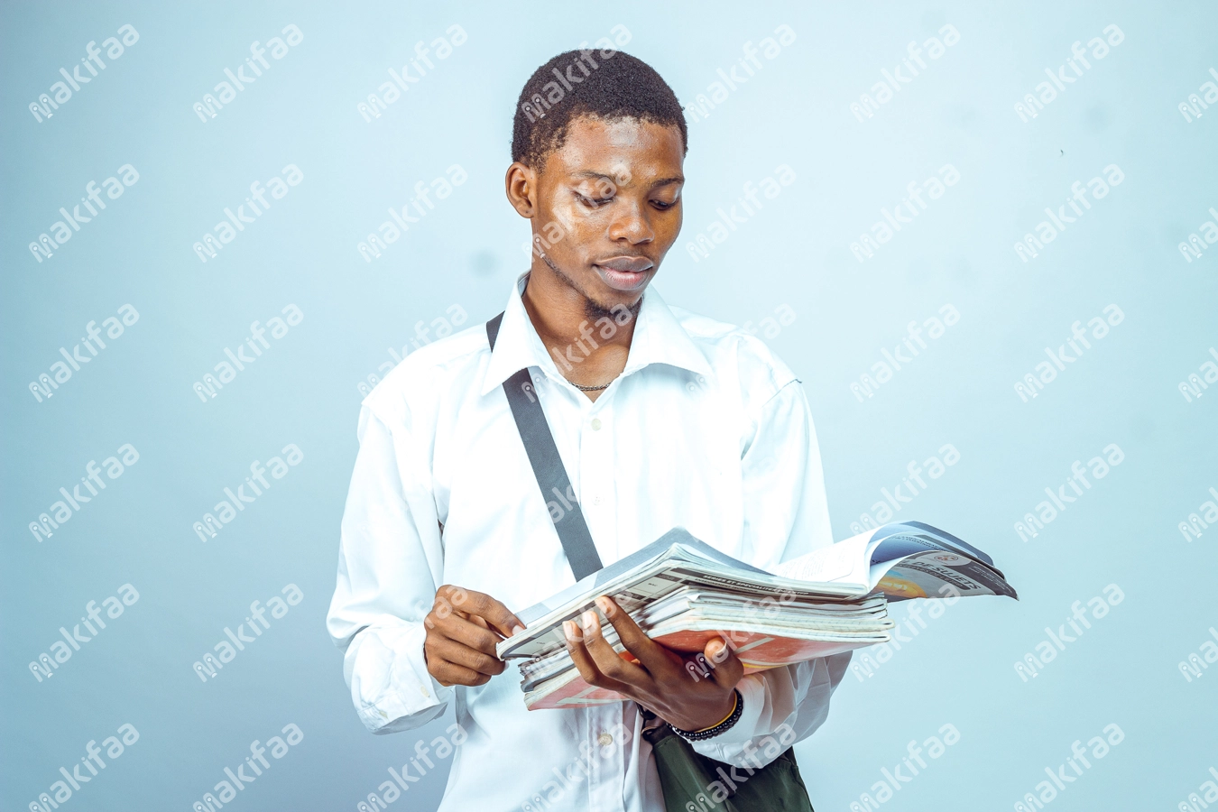 Etudiant studieux lisant dans son cahier avec son sac au dos