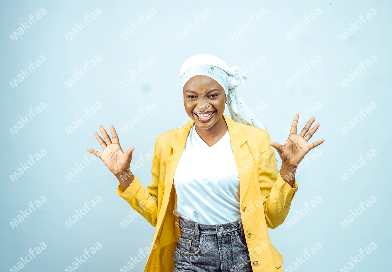 Femme avec fou rire, avec une veste jaune, un foulard et les mains en l'air