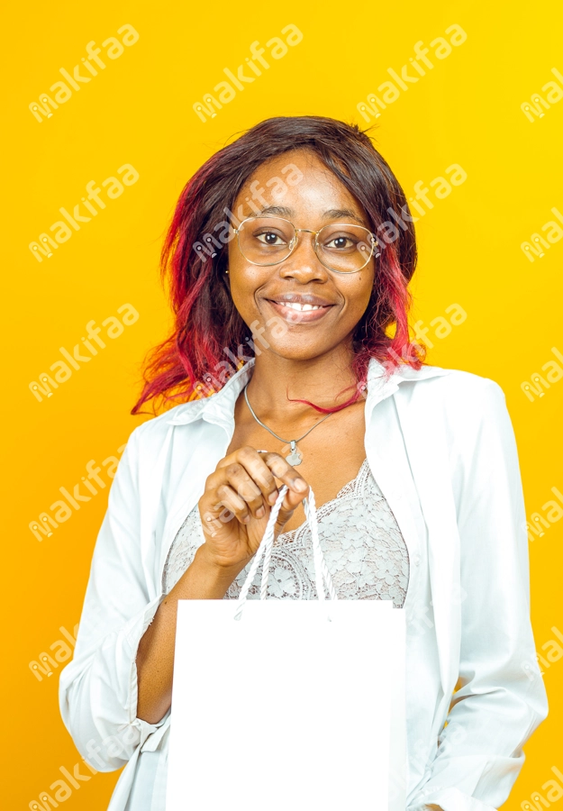 femme contente tenant un sac de shopping