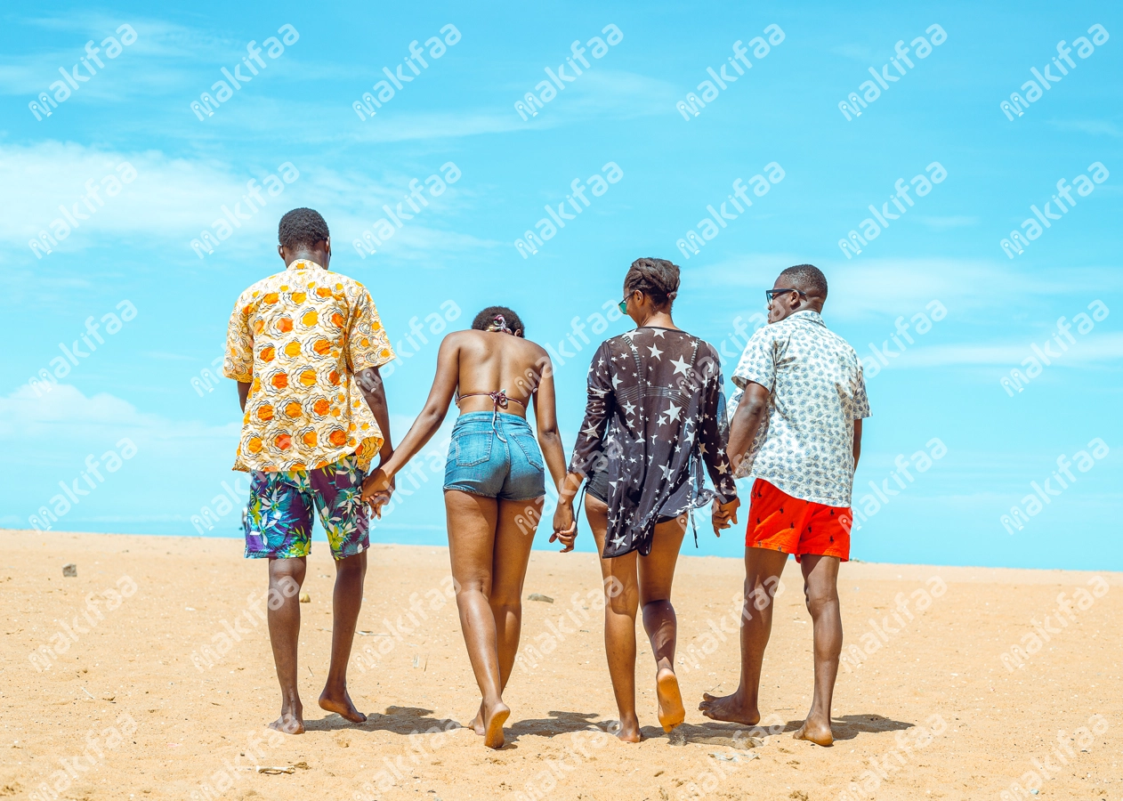 groupe de jeunes couples se promenant à la plage