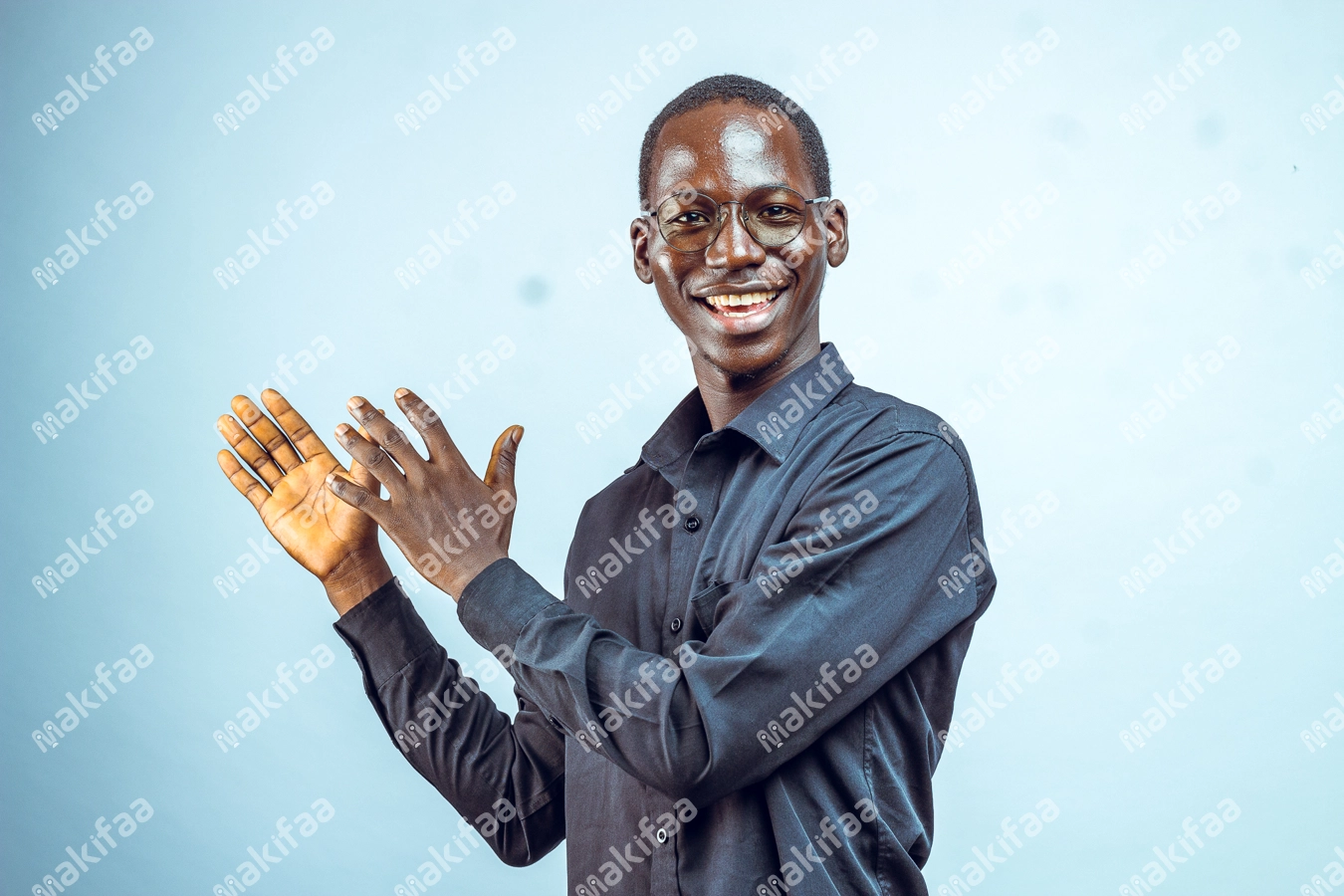 Homme avec des lunettes souriant montrant des produits avec ses mains