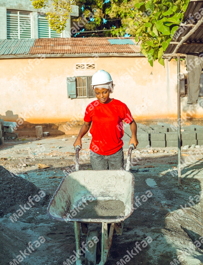 jeune fille sur un chantier de construction poussant une brouette