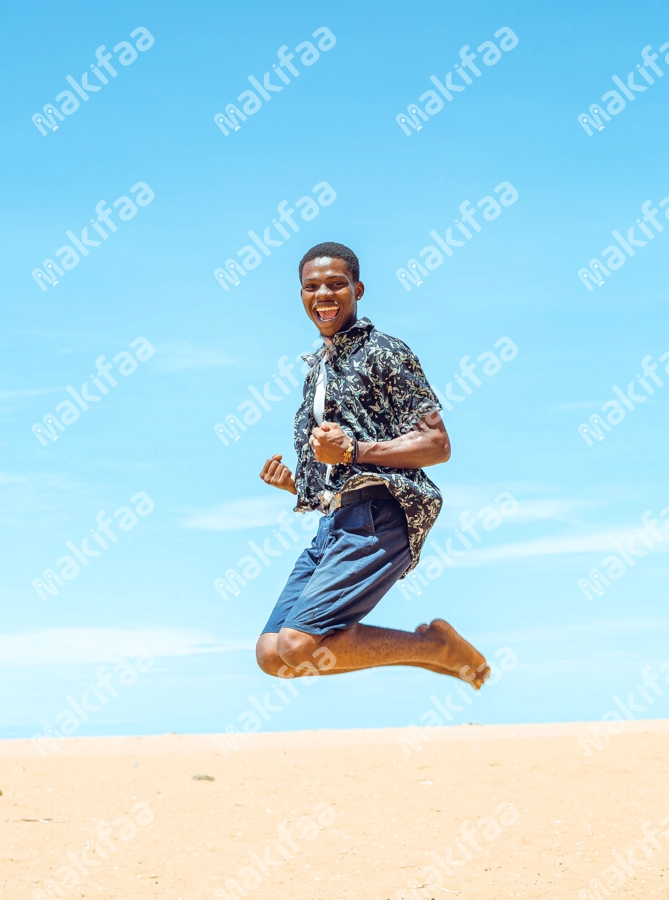 jeune homme faisant un grand saut et joie à la plage