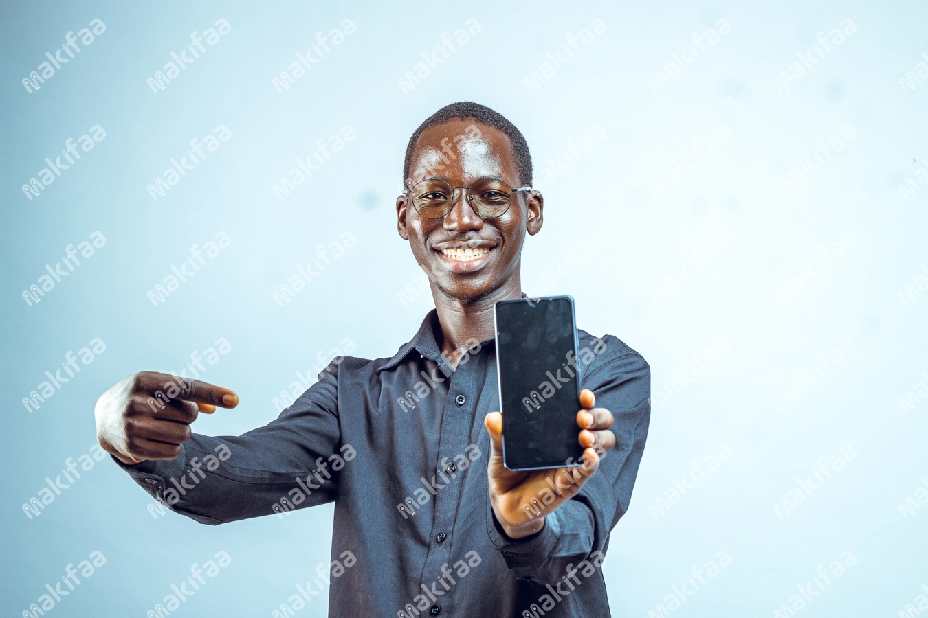 jeune homme portant des lunettes pointant son téléphone