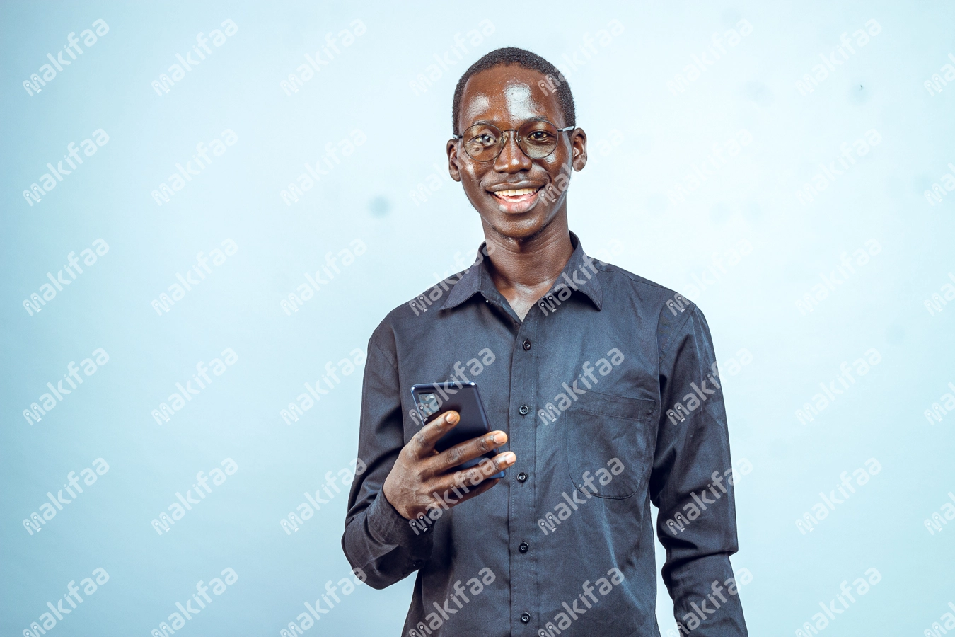 jeune homme portant des lunettes un téléphone en main