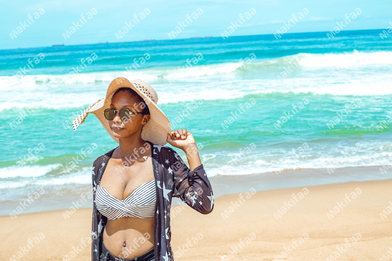 Femme en chapeau de soleil en bordure de plage