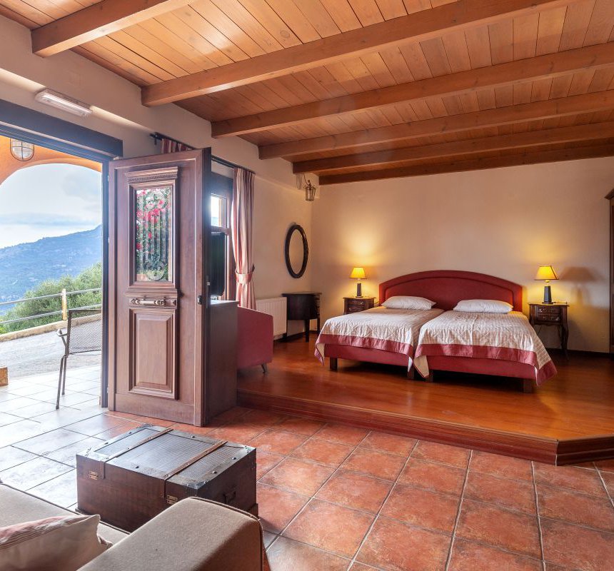 The interior of the residence with the single beds, the white walls and wooden ceiling