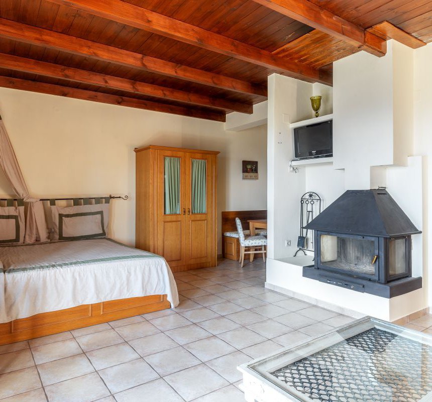 The interior of the residence with the bed and the curtains around it, the coffee table, the closet, the fireplace and the TV