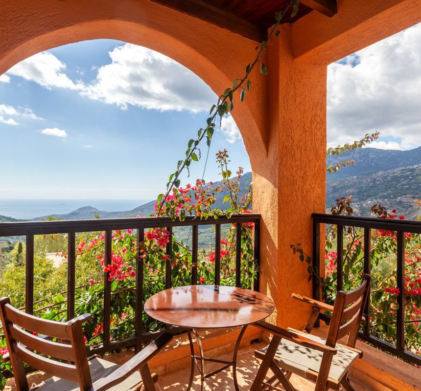 The view of the Malles mountains and the sea from the balcony of the maisonette with the greenery around it