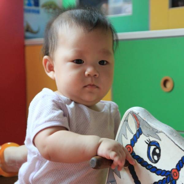 第一次坐木馬，表情有不安的感覺