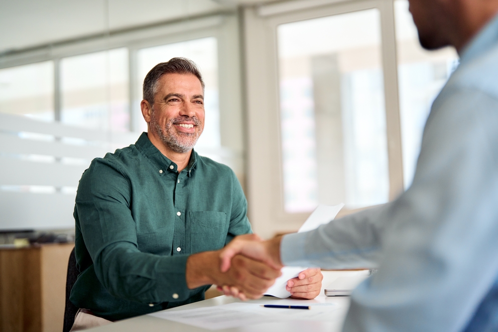 Smiling businessman shaking hands with his partner