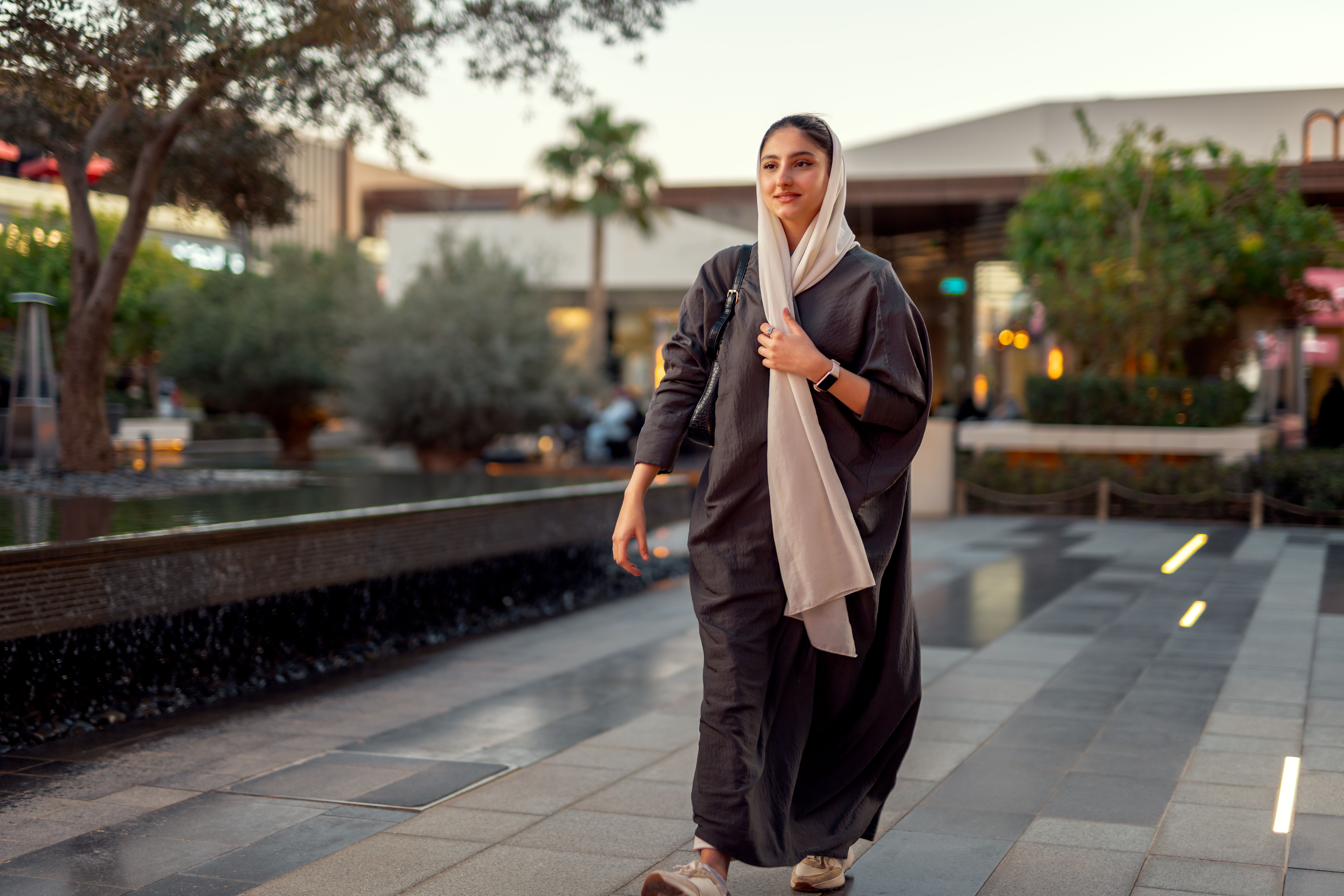 Professional woman walking in a ROSHN Group real estate property