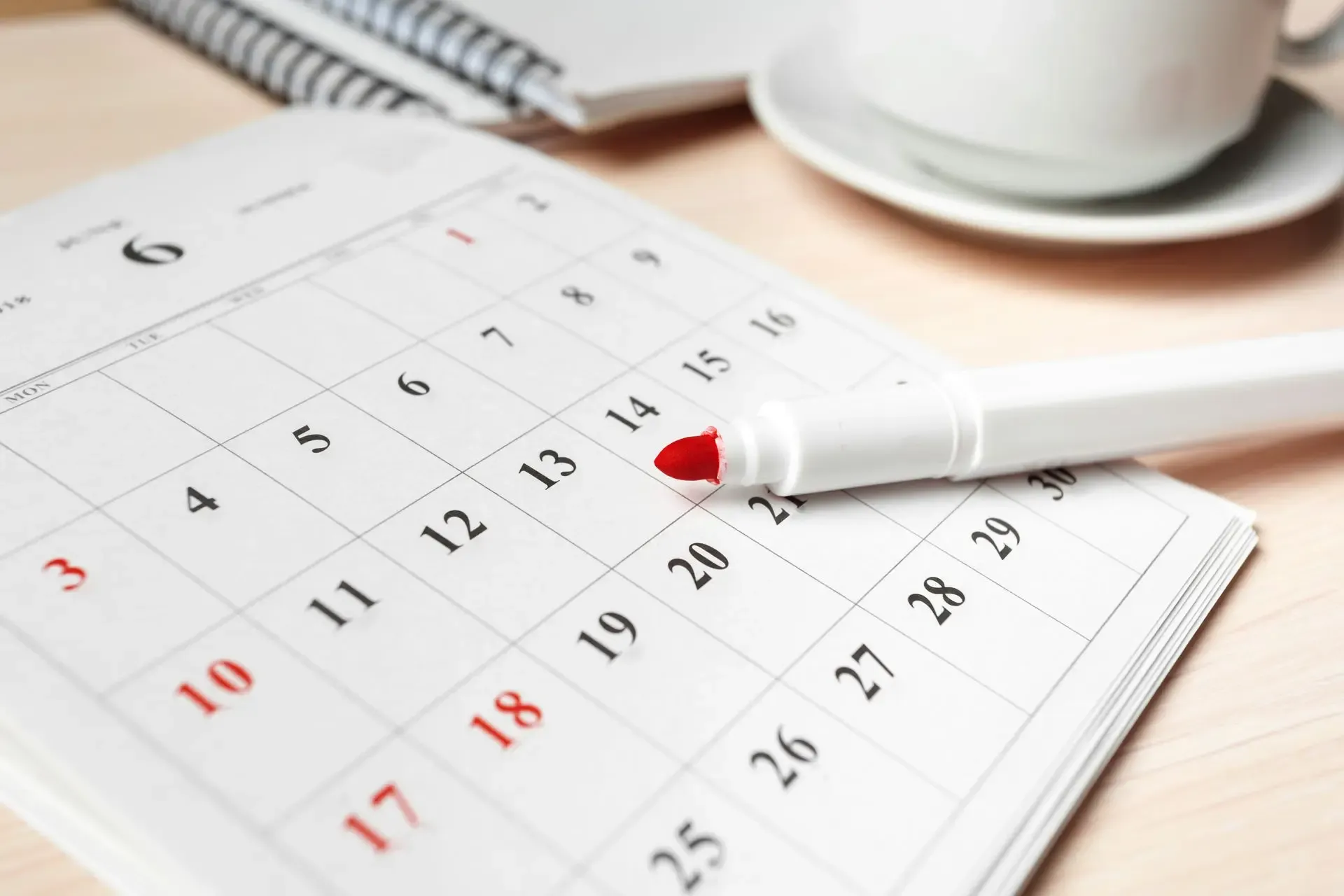 Open calendar with red marker highlighting a date, suggesting deadline or important appointment scheduling