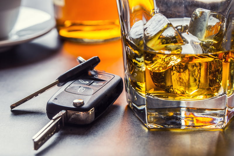 Car keys next to glasses of whiskey, illustrating impaired driving risks