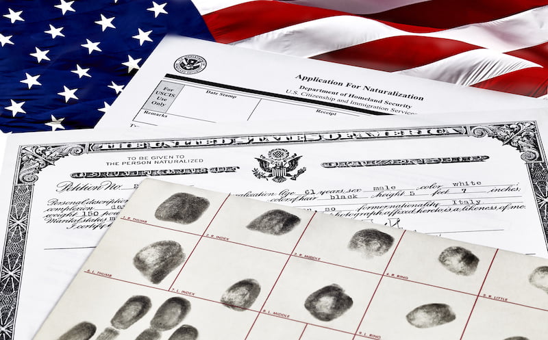 US citizenship naturalization application form with fingerprints and American flag background