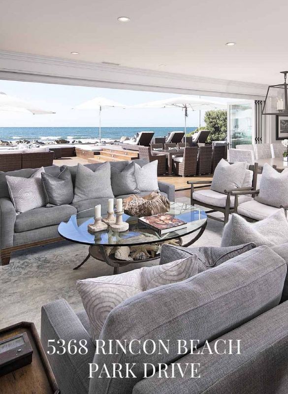 living room couches and table with view of outside deck and ocean