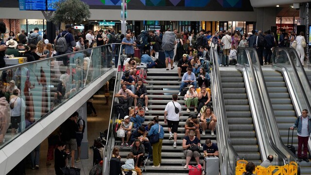 Reisende sitzen auf einer Treppe am Gare de Montparnasse vor den Olympischen Sommerspielen 2024. Wenige Stunden vor der Eröffnung der Olympischen Spiele in Paris haben Unbekannte Brandanschläge auf mehreren Anlagen des französischen Schnellzugnetzes verübt. (Foto: dpa Bildfunk, picture alliance/dpa/AP | Yasin Dar)