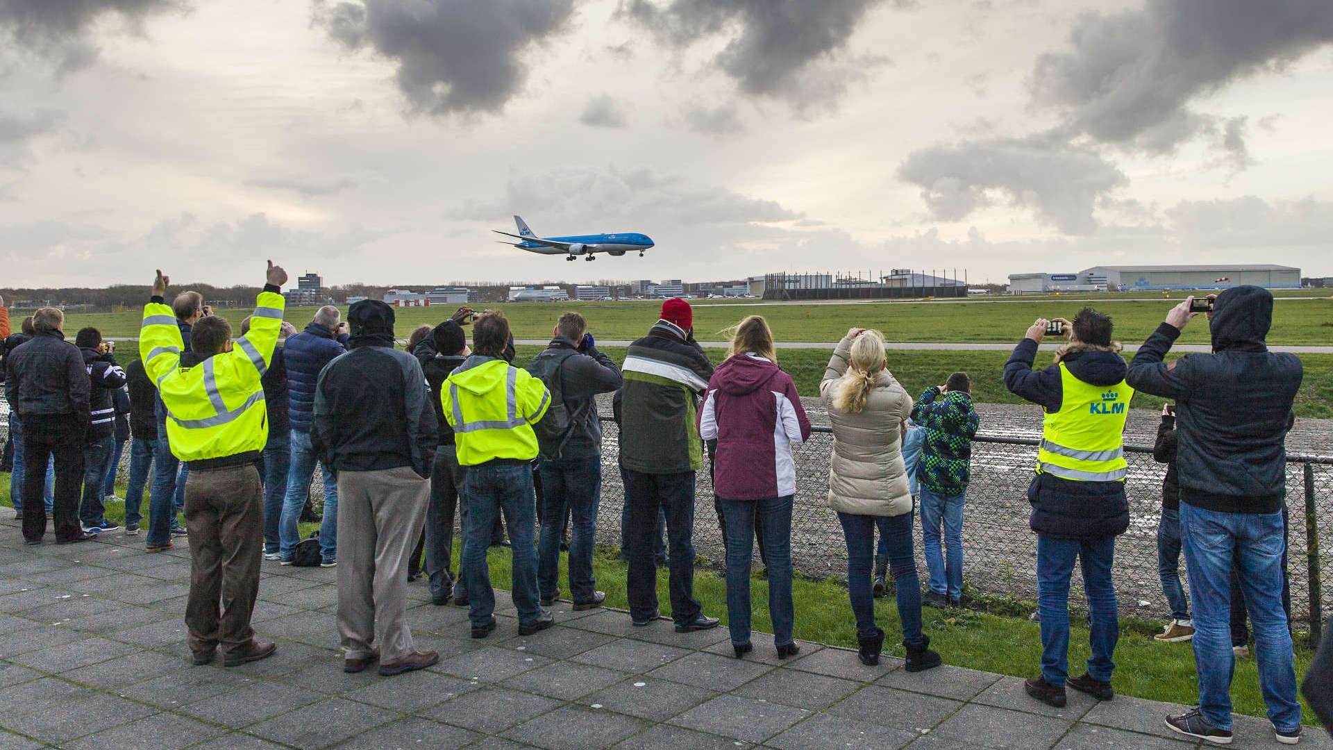 Bezoekers op Schiphol bekijken de nieuwe binnenkomende Dreamliner 787 van KLM