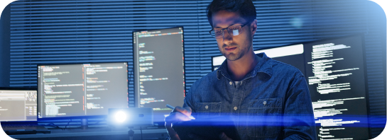 Hispanic developer engineer use digital tablet in an office with computer screens