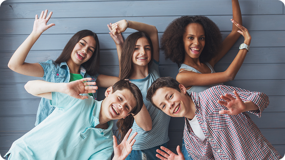 Group of teenage boys and girls smiling looking at camera