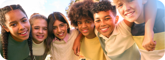 Group of young kids outside in a group hug