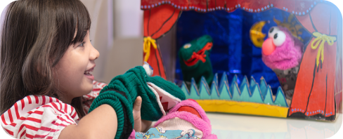 Little girl delighting in puppet play