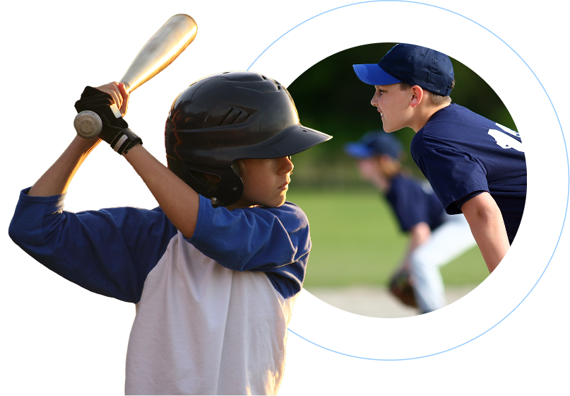 A young kid wearing a baseball hat and holding a bat ready to hit the ball and a second young kid in a baseball outfit in the midfield position.