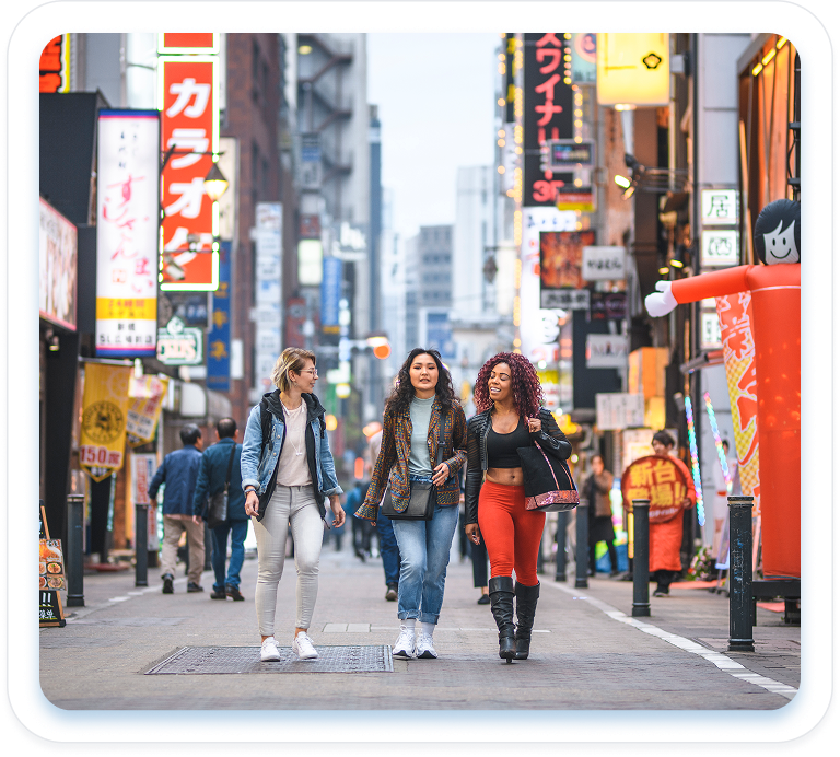 Three people walking in a busy street in Asia