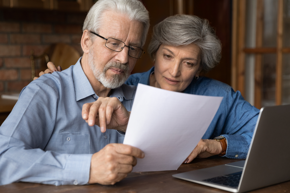 A senior couple looks at a piece of paper