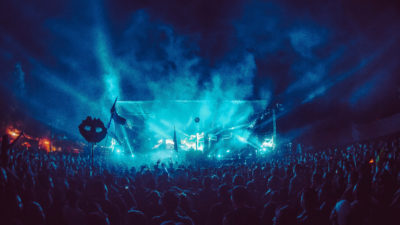 festival stage in blue lights with totems