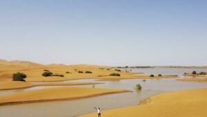 Un hombre camina sobre las dunas de arena junto a un lago provocado por las fuertes lluvias en la ciudad desértica de Merzouga, cerca de Rachidia, al sureste de Marruecos, el miércoles 2 de octubre de 2024. Crédito: AP