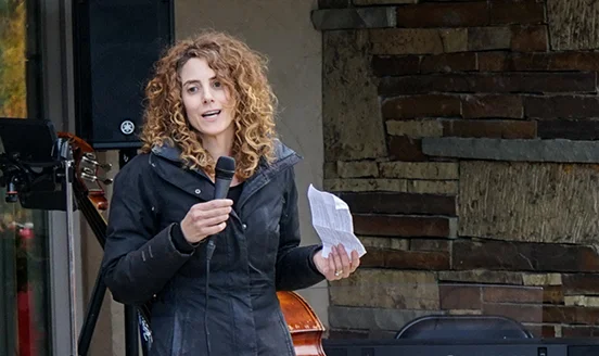 Stacy Feldman, founder of Boulder Reporting lab, speaks at an outdoor event