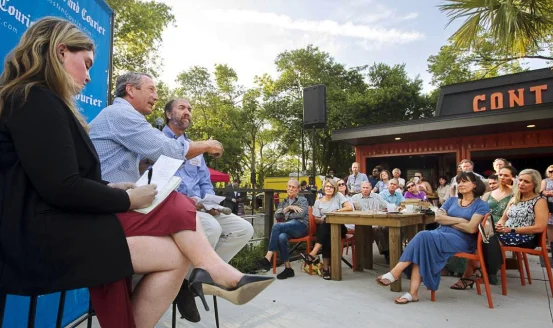 Three Post and Courier staff members answer questions at an outdoor event