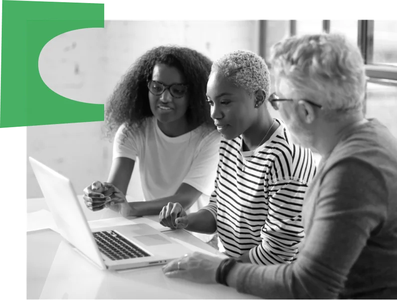 Group of three people happily using a laptop together