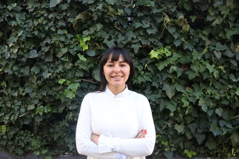 Headshot of Lina Torres in front of a leafy background