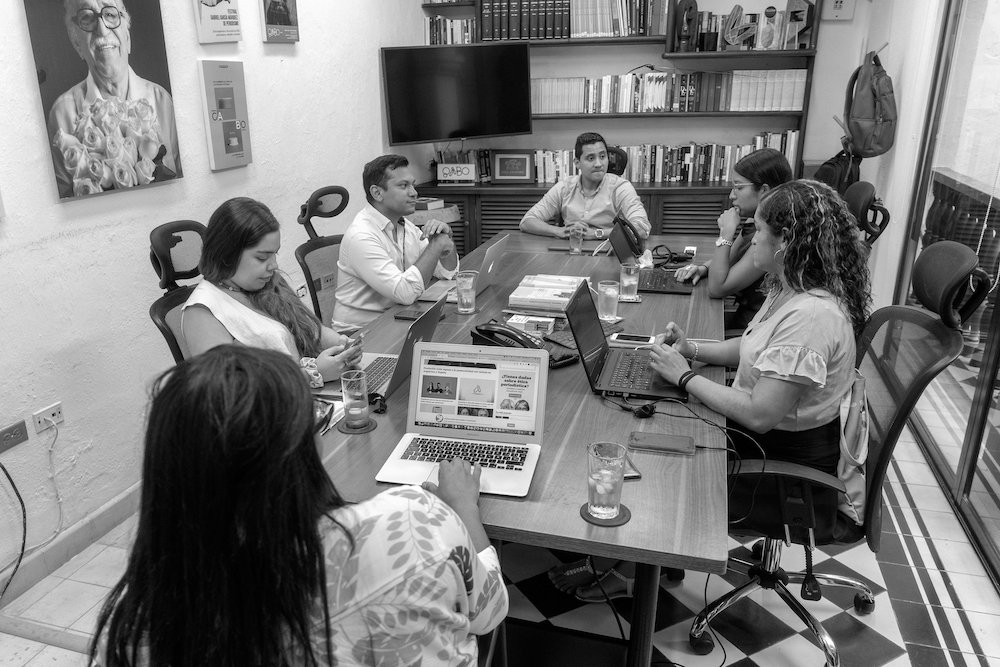 Fundación Gabo members gathered around a conference tail in black and white