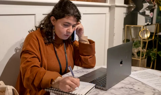 San José Spotlight Journalist Jana Kadah takes notes while listening on her phone