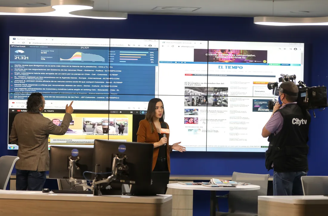 El Tiempo staff in front of a large screen