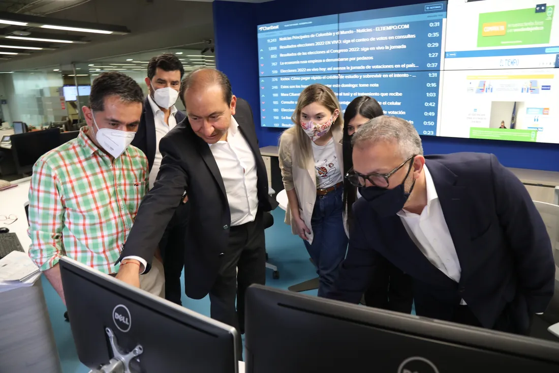 El Tiempo members looking at a computer screen