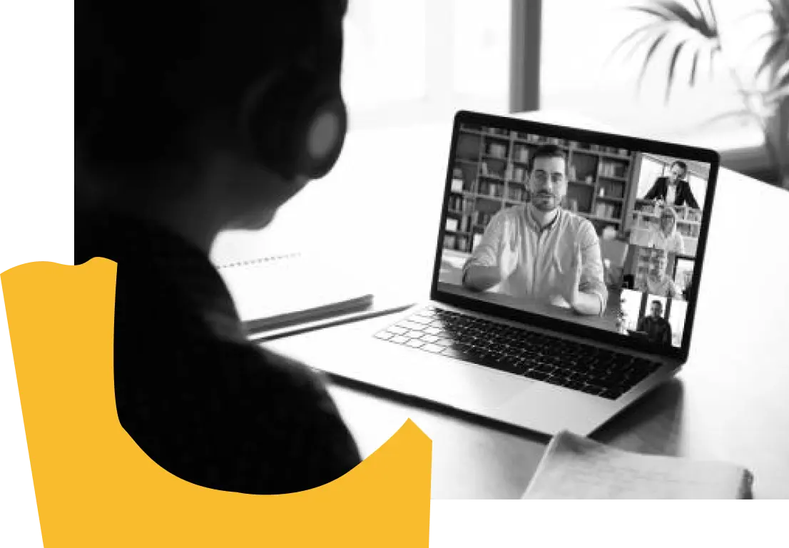 Black and white photo of person video conferencing with another on a laptop