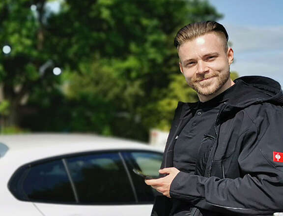 Felix Zehl, Sanierungsberater der RENEWA neben einem Auto