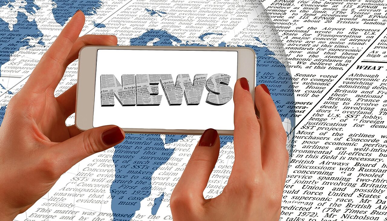 Hände, Smartphone & "News" Hände halten Smartphone auf dem "News" steht