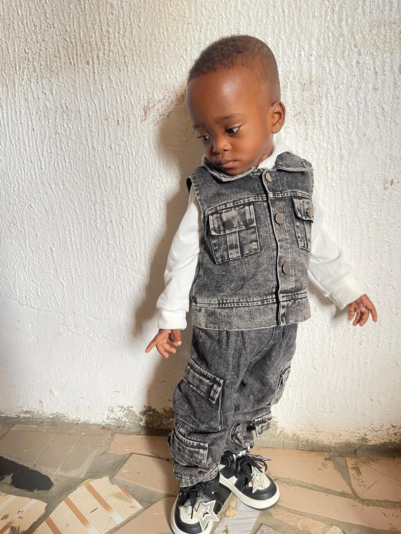 Change his background to studio photoshoot background The glossy floor creates a clear reflection of the number and its lights. keep his face, skin tone, and facial features exactly the same. keep the exact real face, hairstyle, and skin tone unchanged.