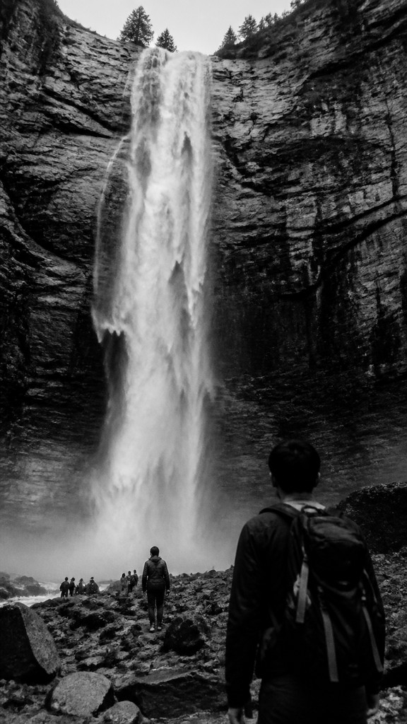 towering waterfall cascading down a cliff — Street Photography Style