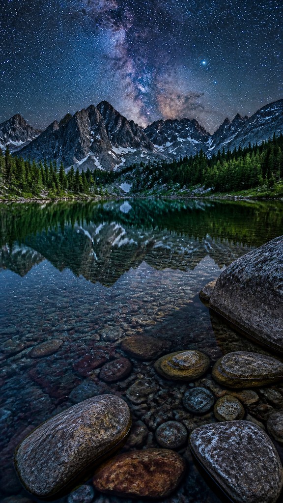 a tranquil mountain lake beneath a starry night sky, no people, no text — Hyperrealism Art Style phone wallpaper
