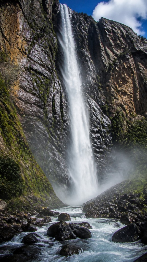 towering waterfall cascading down a cliff — Photorealism Art Style