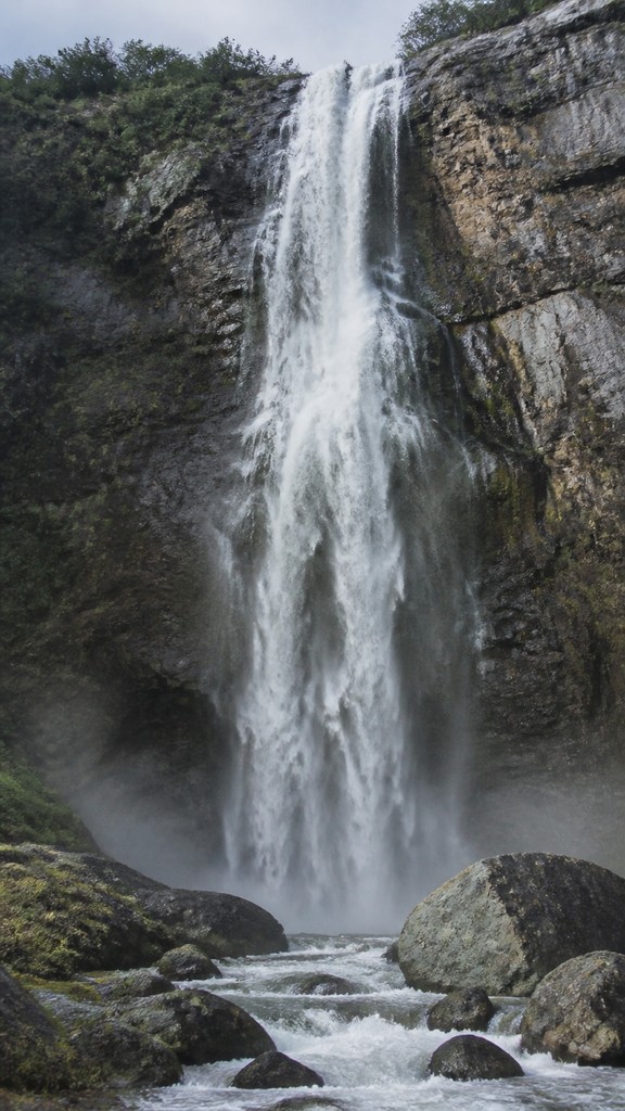 towering waterfall cascading down a cliff — Contemporary Realism Art Style