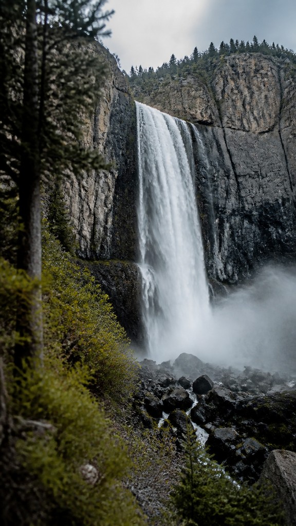 towering waterfall cascading down a cliff — Documentary Photography Style