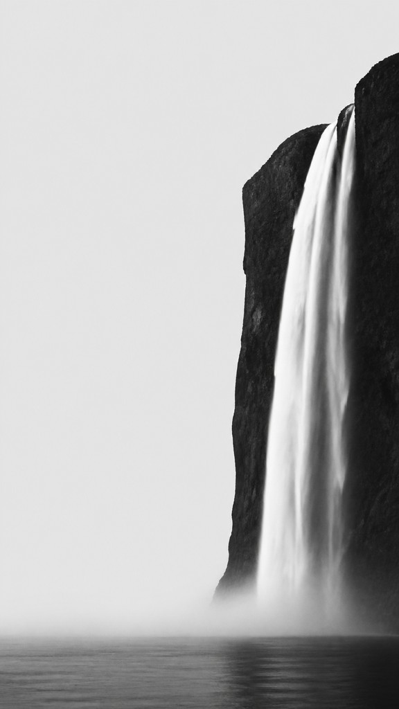 towering waterfall cascading down a cliff — Minimalist Photography Style
